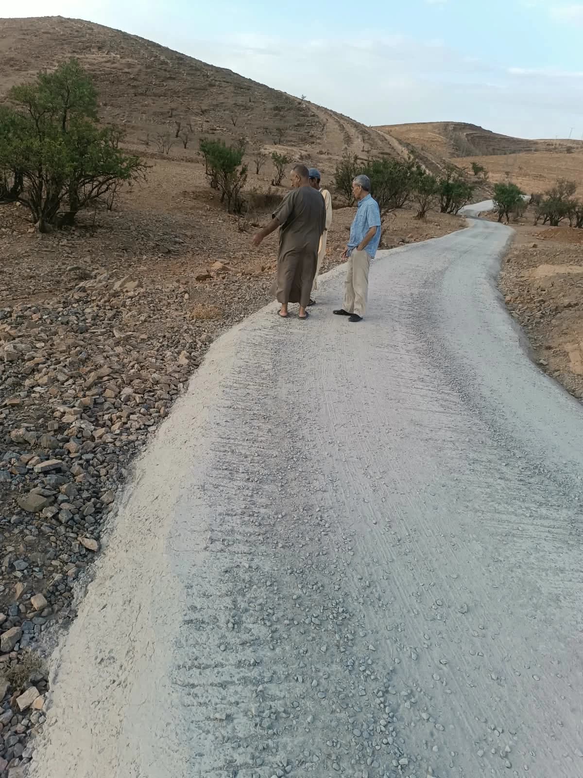 الطريق الصاعدة نحو القرية بتبليطها الجديد، بين الأشجار والجبل، وثلاثة رجال واقفون عليها يتفقّدونها.